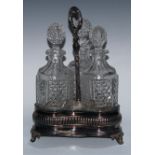 An Adam Revival EPNS and cut-glass three-bottle decanter stand, the trefoil-shaped base engraved