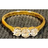 An 18ct gold three stone brilliant cut diamond ring, size P, 2g