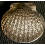 A silver shell shaped pill box