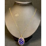 A 19th century French enamelled fleur de Lys gold plated mourning pendant, on a later 9ct gold chain