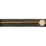 A gold and diamond flower head stick pin, unmarked, probably 15ct, the central brilliant cut stone