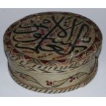 A Middle Eastern Islamic polychrome painted softwood circular box, the cover inscribed with Arabic