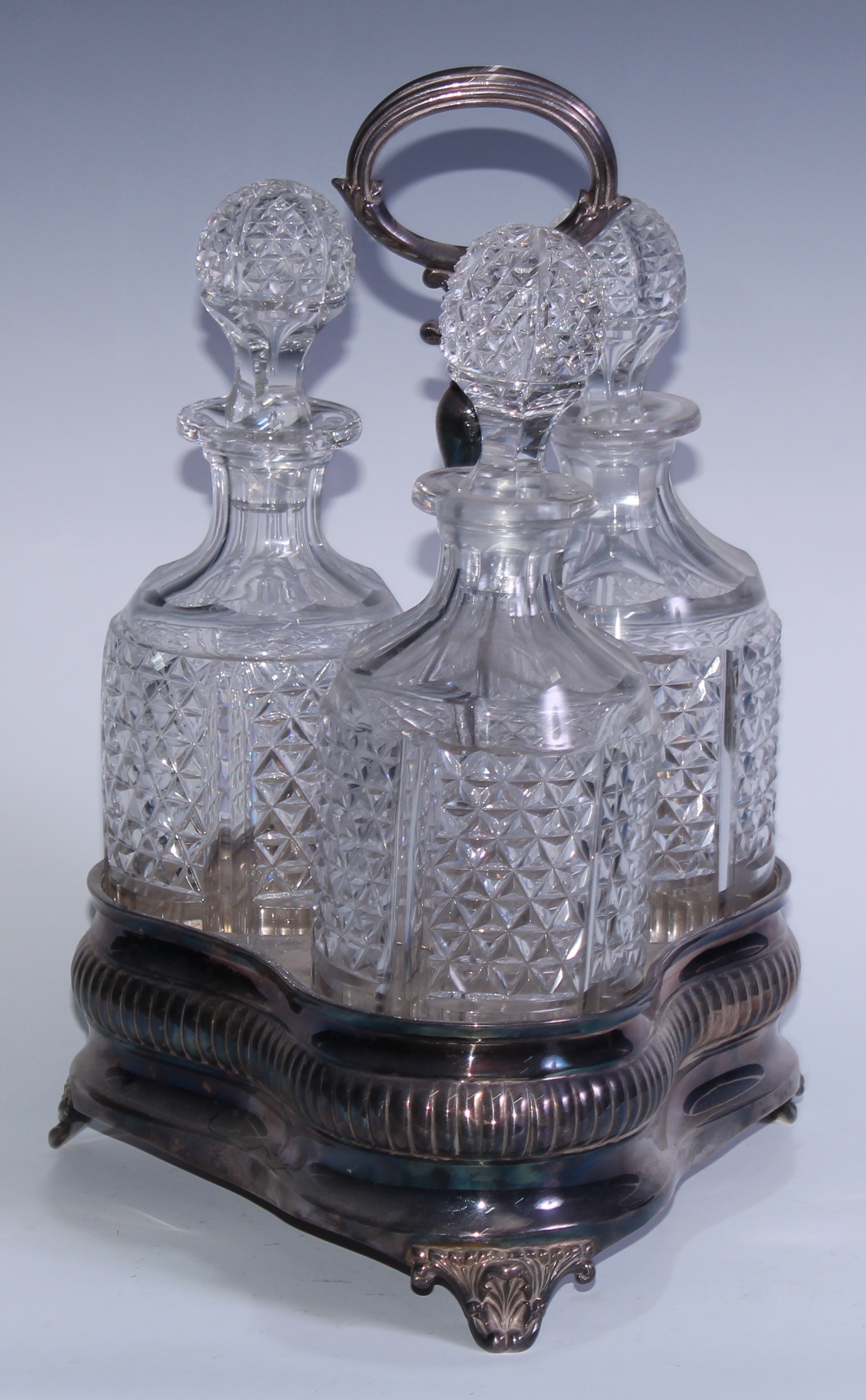 An Adam Revival EPNS and cut-glass three-bottle decanter stand, the trefoil-shaped base engraved - Image 2 of 3