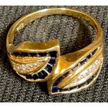 An 18ct gold diamond and sapphire leaf shaped crossover ring, marked 750, ring size Q, 5.3g