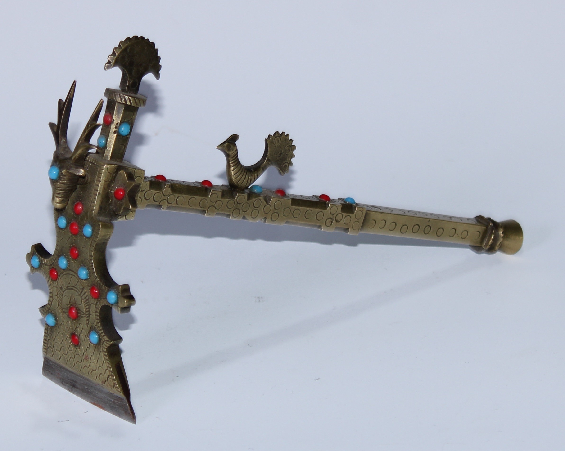 A Tibetan brass ceremonial adze, steel blade, deer and peacock crestings, applied with coral and