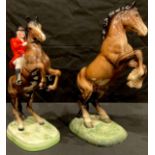 A Beswick model of a huntsman on rearing bay horse, number 868, 24cm, printed and impressed marks;