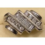 A 14k white gold diamond ring, the central row of seven baguette cut stones flanked by two rows of