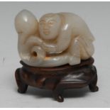 A Chinese pale jade carving, of a boy grasping a peach, 7cm wide, matched hardwood stand