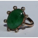 An Edwardian oval cabochon jade and seed pearl ring, rose metal mount stamped 9ct, size H, 3.9g