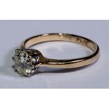 An 18ct gold diamond solitaire ring, platinum bezel, the brilliant cut stone with a slight yellow