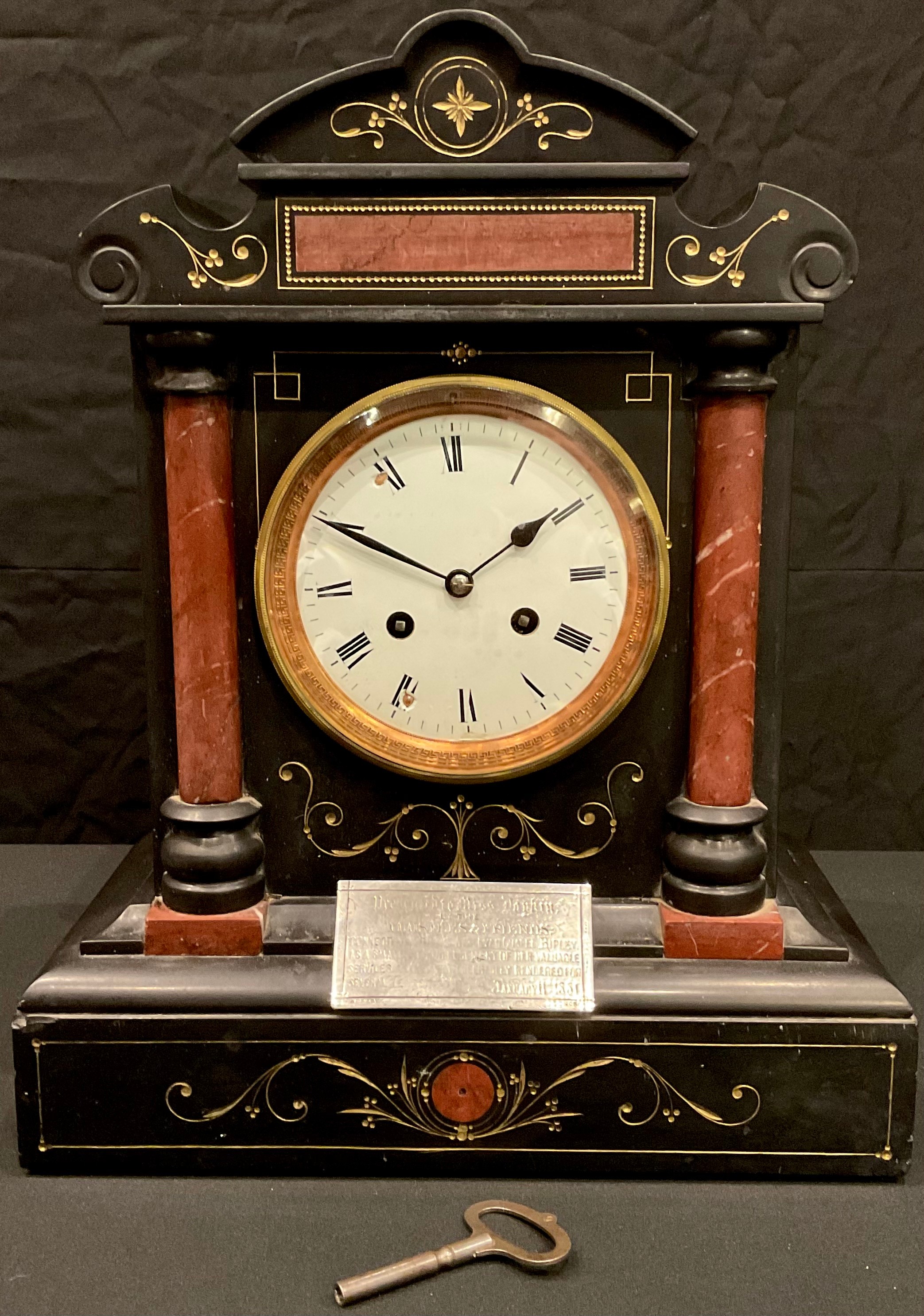 A late 19th century French black slate and rouge marble architectural mantel clock, white enamel