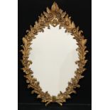 An Italian giltwood looking glass or wall mirror, the frame carved with leaves and flowerheads,