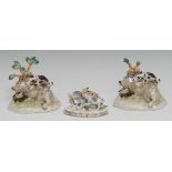 A pair of Staffordshire porcelainous models, of a wild boar being attacked by two dogs, shaped