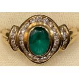 An 18ct gold emerald and diamond ring, the central faceted green stone surrounded by eighteen