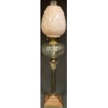 A late Victorian brass oil lamp, twin burner, opaque moulded pink glass shade, chimney