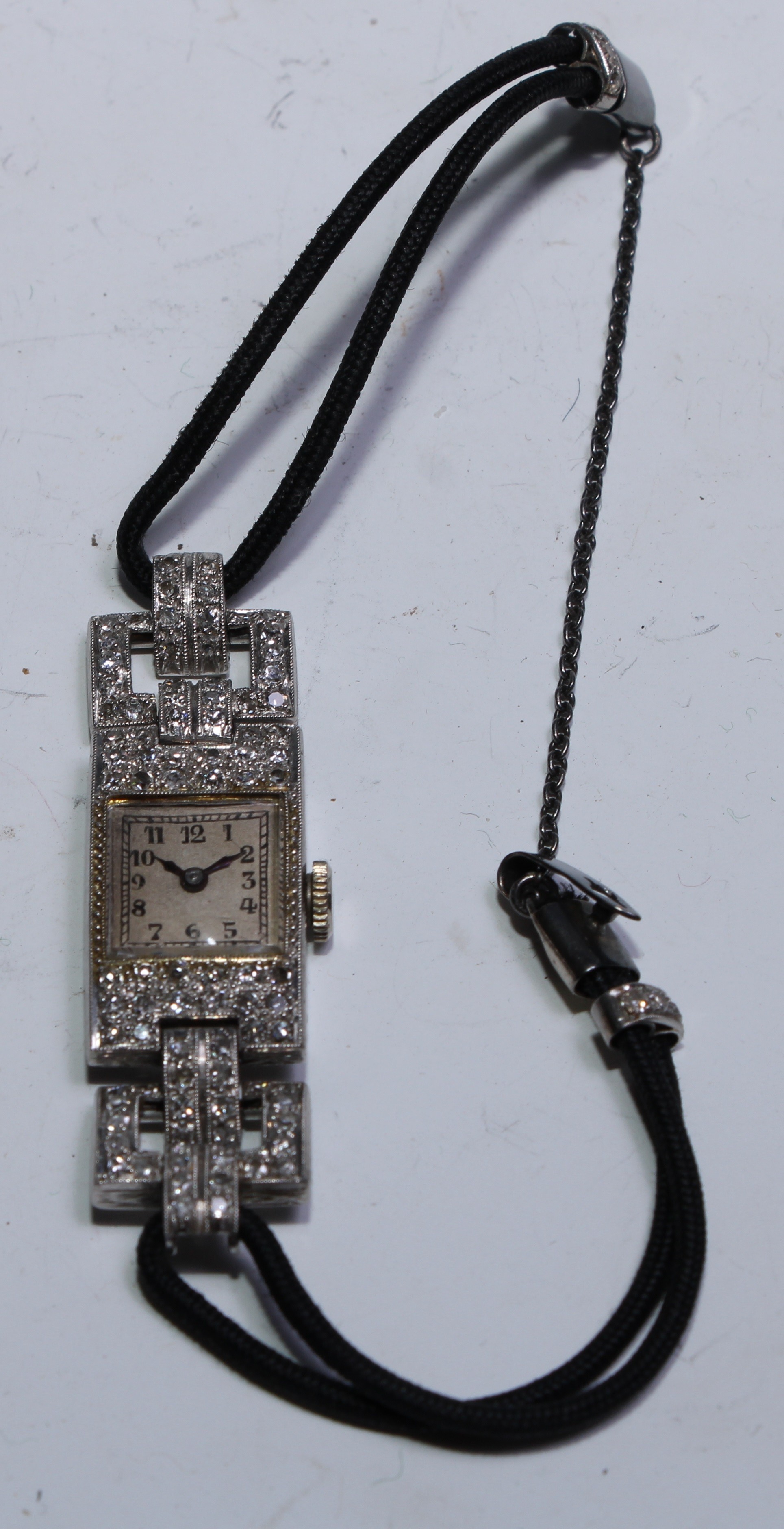 An Art Deco diamond encrusted cocktail watch, square silvered dial, Arabic numerals, blues hands,