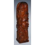 An adzed oak library desk sculpture, as a multi-bust totem pole, carved with heads from varying