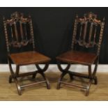A pair of Renaissance Revival design oak hall chairs, each crested by a vacant cartouche supported