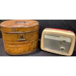 A brown painted tin oval top hat box, hinged cover, swing handle, 26cm; a Defiant radio receiver,