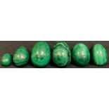 A set of six graduated polished malachite eggs, the largest 8cm