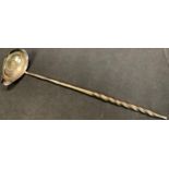 An 18th century silver coloured toddy ladle, whale bone handle, the bowl later inset with a 1725