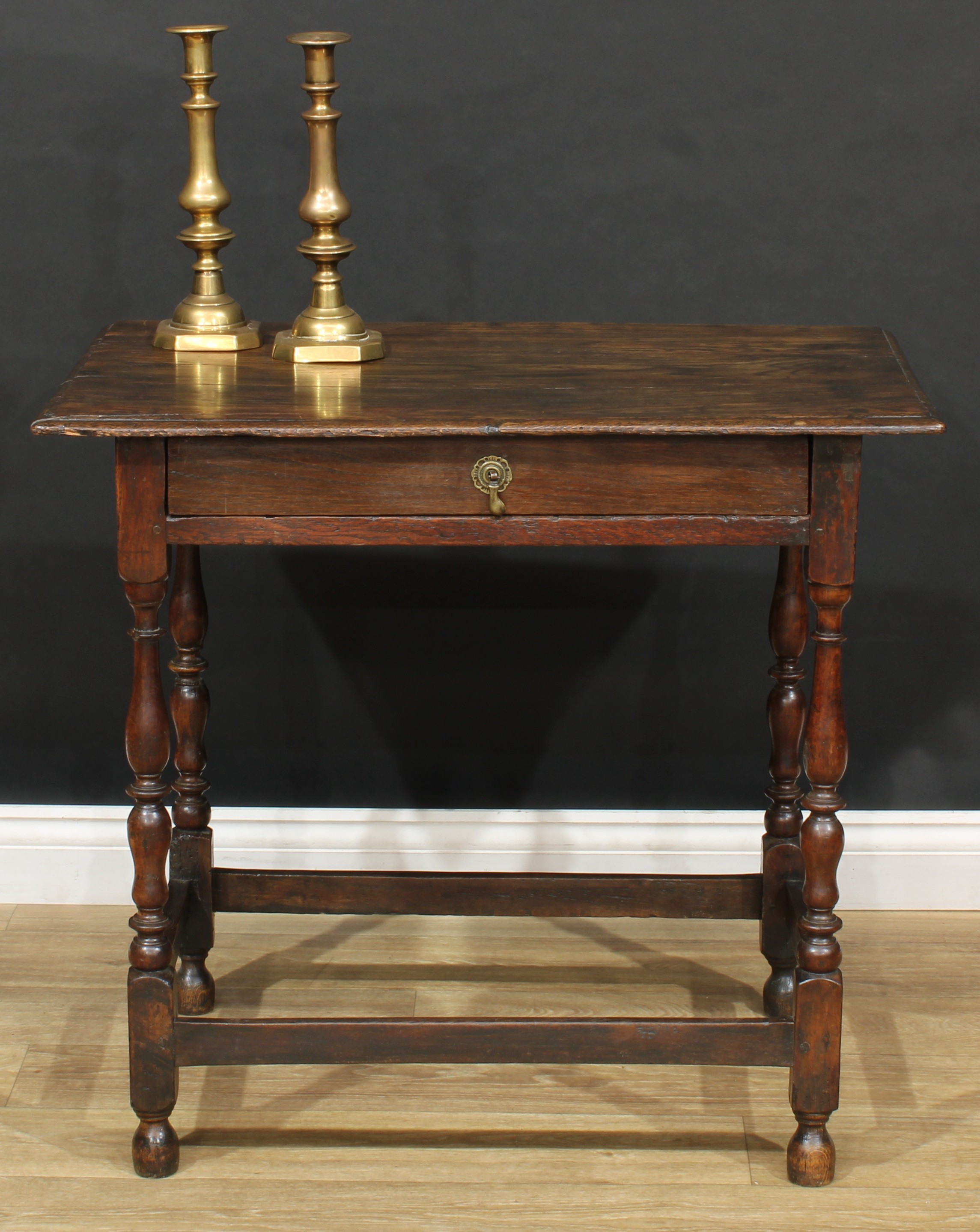 An 18th century design oak side table, oversailing top above a long frieze drawer, turned