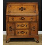 An early to mid-20th century oak bureau, fall front enclosing small drawers and pigeonholes, above