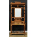 An Arts & Crafts mahogany hall stand, central rectangular mirror above a panel carved in the Art