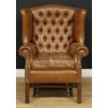 A George III style 'Chesterfield' wingback armchair, 110cm high, 84cm wide, the seat 44cm wide and