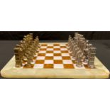 A cast metal chess set with an onyx chess board, 45cm wide