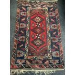 A Persian style woollen rug, in shades of brown and red on a blue ground, 122cm wide; another