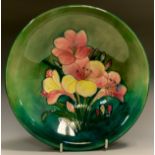 A Moorcroft Freesia pattern bowl, tubed lined with flowers in tones of red and yellow on a mottled