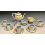 A Susie Cooper Crown Works coffee service, for six, each banded in brown, blue interiors, printed