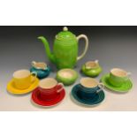 A Susie Cooper coffee service, for four, each with a different vibrant colour, banded in white,