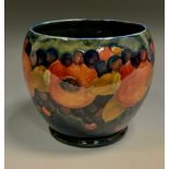 A Moorcroft Pomegranate pattern jardiniere, tube lined with fruit, on a blue blue ground, 16cm high,