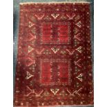 A Middle Eastern woollen rug, in tones of red, geometrical motifs, 1780cm x 232cm