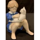 A Royal Copenhagen model of a young girl sitting down with a Cat on her raised knees, modelled by