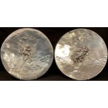 A pair of French Art Nouveau polished pewter circular plaques, relief decorated, Aurore (Dawn) and