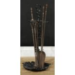 A Coalbrookdale style walking stick or umbrella stand, 68cm high; a fireside companion set; a poker