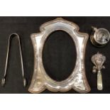 An Edwardian silver photograph frame, London 1902; a George V silver baby's rattle, Birmingham 1911;