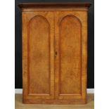 A Victorian walnut wardrobe, outswept cornice above a pair of panel doors, the left fitted as a