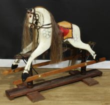 A 20th century rocking horse on a later replacement safety stand, the carved and later over-