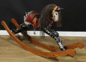 A 20th century rocking horse on a bow rocker, the carved and later over-painted/re-painted dappled