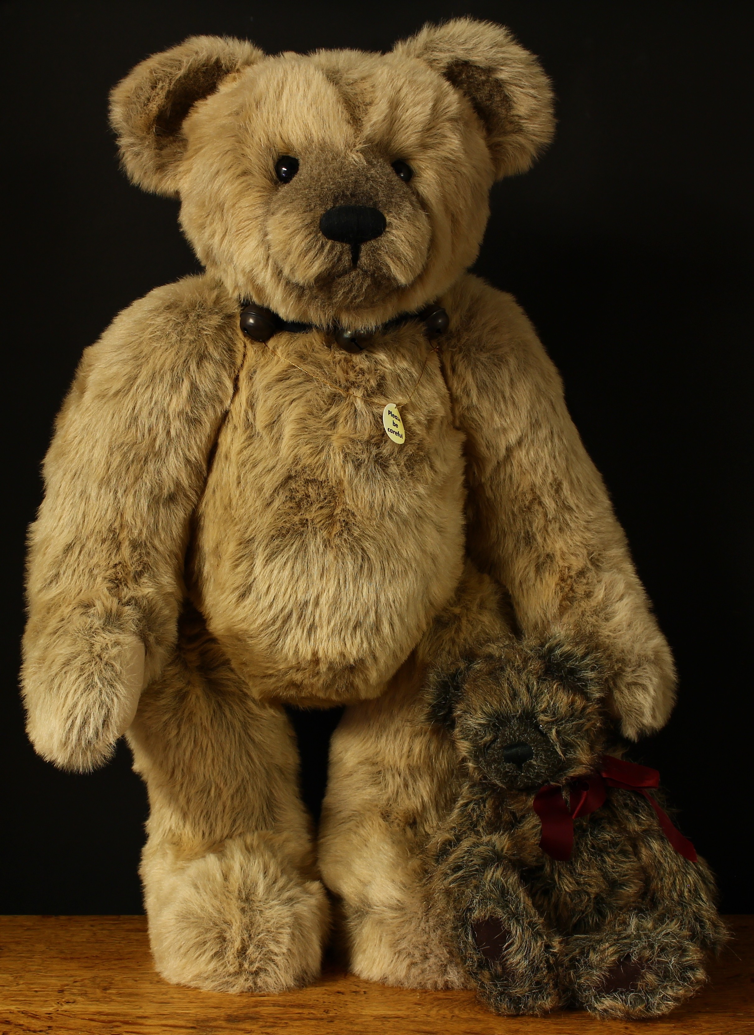 A large Charlie Bears teddy bear with ribbon collar and bells around neck, 76cm high; another
