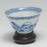 A Chinese lotus wine cup, painted in tones of underglaze blue with an erotic scene, the exterior
