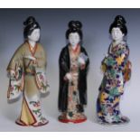 H. Senda Komatsu, Japanese figure, of a Geisha, standing wearing flowing robes holding a book,