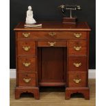 A 19th century mahogany kneehole desk, three-quarter crossbanded rectangular top above an