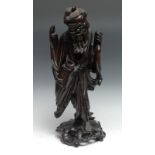 A Chinese hardwood figure, of a elder, bone teeth, holding a carp and vase, pierced base, 44cm high,