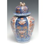A Japanese ovoid temple jar and cover, painted in the Imari palette with flowers and vessels, 31.5cm