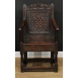 A 17th century oak Wainscot armchair, shaped cresting rail, panel back carved with a flowerhead